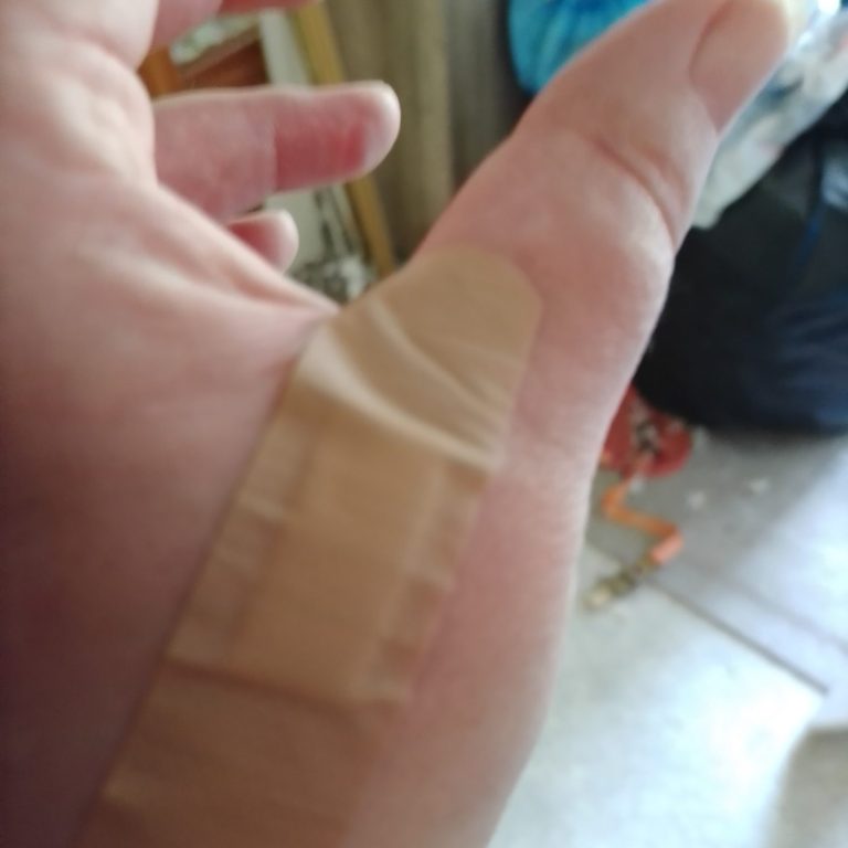 Ein Finger mit einem Pflaster auf der oberen Fläche.