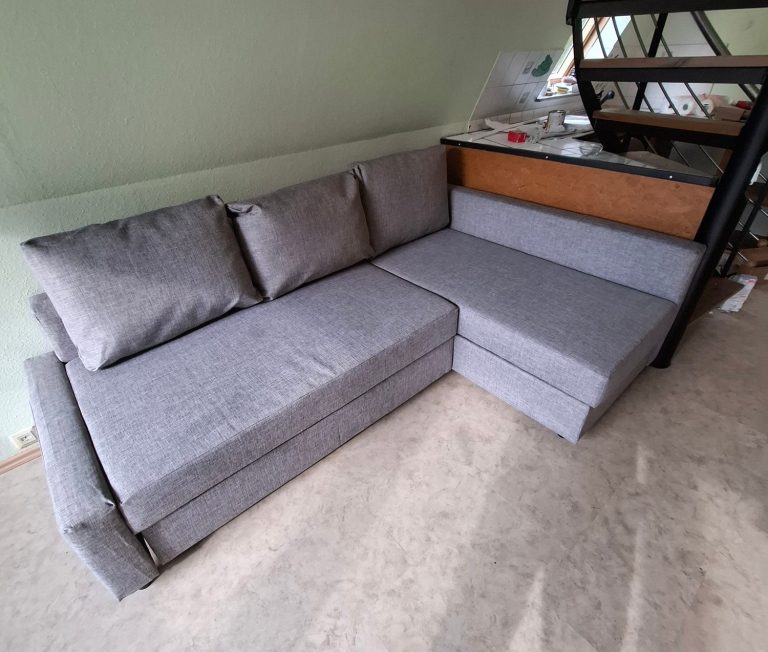 Stube2 Grau gepolsterte U-förmige Couch im Wohnraum.