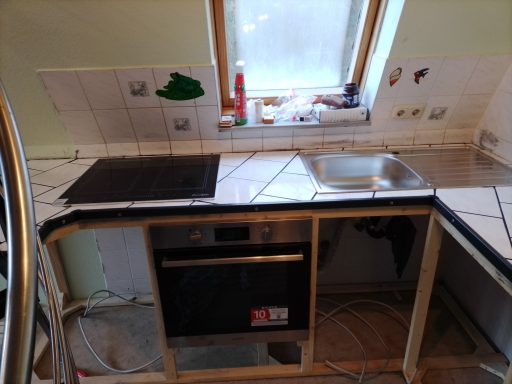 Küchenzeile mit Spüle, eingebautem Geschirrspüler und Freiräumen für weitere Möbel.