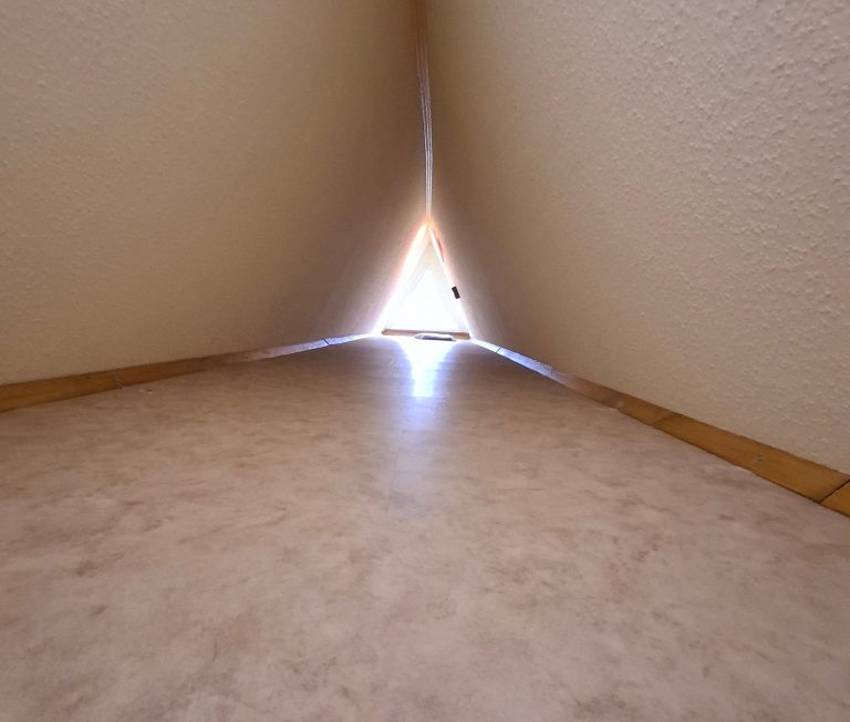 Extraraum Ein spitzer Durchgang zwischen zwei Wänden, mit Licht am Ende des Tunnels.