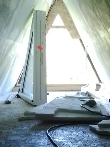 Blick auf einen Raum mit Bauzubehör und einem geöffneten Fenster.